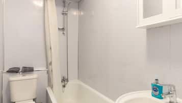 Ein Badezimmer mit Badewanne, Toilette, Waschbecken und Spiegel.