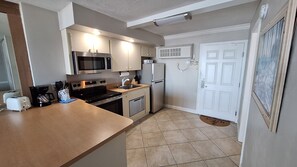 Cocina compacta con microondas, estufa y refrigerador.