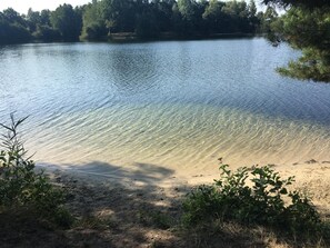 A clear lake with a sandy shore and some vegetation in the foreground. - Cozy, rustic house with a fireplace, large garden, and 2 bathrooms for up to 6 people (Schüttorf)