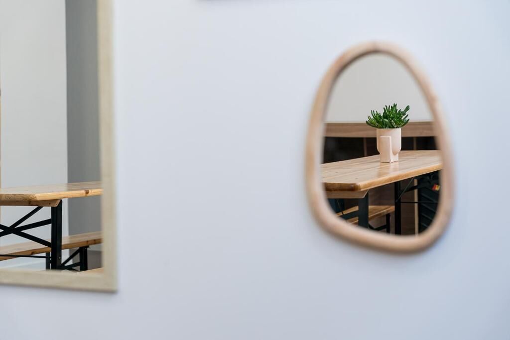 A mirror reflecting a wooden table with a potted plant.