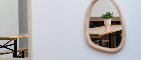 A mirror reflecting a wooden table with a potted plant.