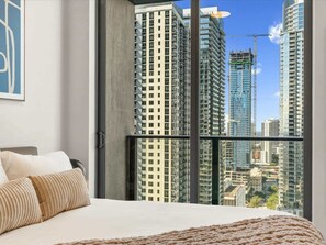 A bedroom with a large window, a bed, and a view of high-rise buildings. - Stylish 1BR+Den | Rooftop Pool | Brickell 5Mi (Miami)