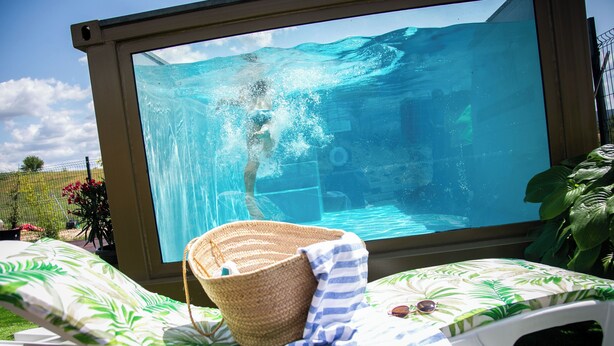 A poolside area with a large window overlooking a swimming pool, a lounge chair, a woven basket, and a striped towel. - RURAL HOUSE THE WILLOW. 2.5 km from the city of Cuenca. Groups of up to 23 people (Nohales)