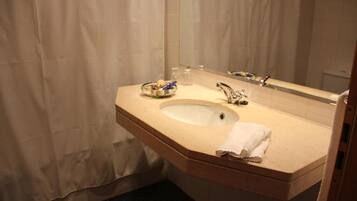 A bathroom with a sink, mirror, and a towel on the counter.