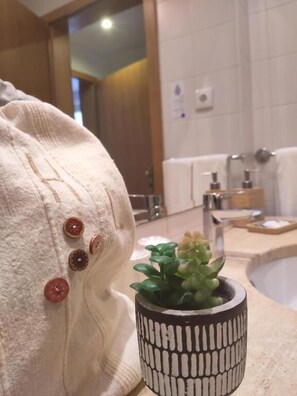 Une salle de bain avec un lavabo, un miroir et un porte-serviettes.