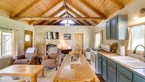 Un intérieur de chalet chaleureux comprenant un coin repas, une cuisine et un espace de vie.