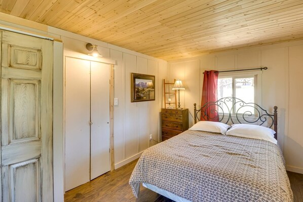 A bedroom with a bed, dresser, and wardrobe.
