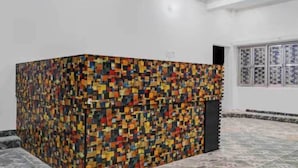 A room with a colorful mosaic wall, a tiled floor, and a window with patterned curtains. - Hotel O Sant Ravidas Ghat Varanasi (Varanasi)