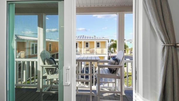 Vista desde un balcón con terraza de madera, una silla y una mesa.