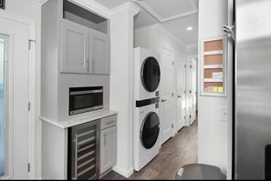 A laundry room with a washing machine, dryer, and microwave. - Coastal Retreat: Pool, Kayak, Beaches & Bikes (Jensen Beach)