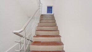 A staircase with metal railings and a small window at the top. - Classic Havens Residency (Chengalpattu)