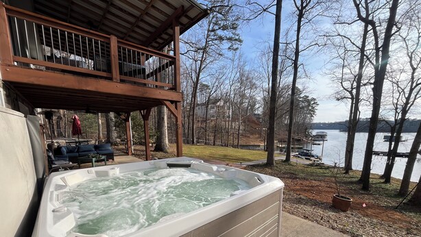 A hot tub with a wooden deck and a view of a lake. - The Shamrock Lake Norman. Swim, fish, kayak, boating, pool, hot tub, jet ski. (Statesville)