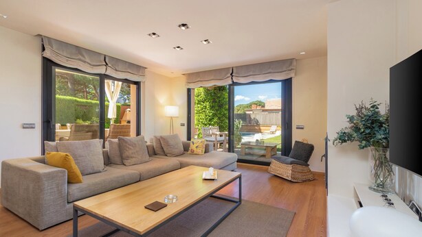 Ein modernes Wohnzimmer mit Sofa, Couchtisch und Fernseher.