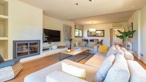 Ein modernes Wohnzimmer mit einer Couch, einem Couchtisch und einem Kamin.