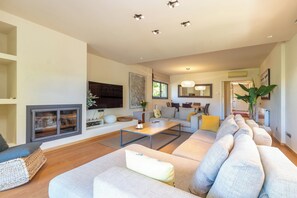 Ein modernes Wohnzimmer mit einer Couch, einem Couchtisch und einem Kamin.