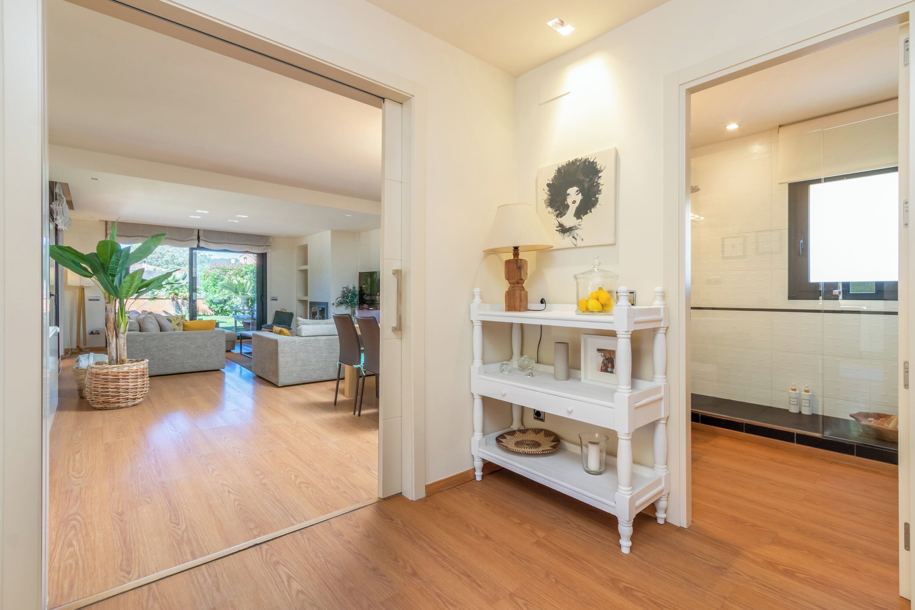 Un espacio moderno para vivir con sofá, mesa de comedor y zona de cocina con un armario blanco.