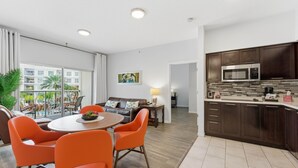 A modern apartment with a dining area, kitchen, and balcony. - Orlando Getaway With Pool View Balcony (Celebration)