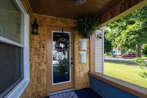 Uma porta de madeira com uma guirlanda, uma caixa de correio e um tapete de boas-vindas.