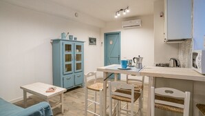 A small, cozy room with a wooden table, two chairs, a blue cabinet, and a kitchenette. - GuestHost - Cozy 35 sqm apartment, perfect for four people, located on the ground floor of a building (access via one step).The property is located in Visgnola, a quiet village near Bellagio, one of Lake Como's most popular destinations. It's well-served (Bellagio)