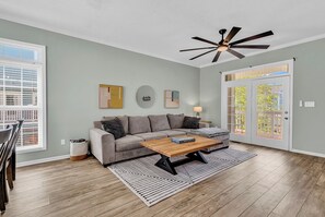 Ein Wohnzimmer mit einer Couch, einem Couchtisch und einem Deckenventilator.