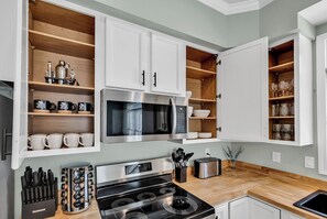 A modern kitchen with white cabinetry, a stainless steel microwave, and a gas stove. - NEW! 2 min walk to Beach + 2 King Master Suites + Family Friendly (Surfside Beach)