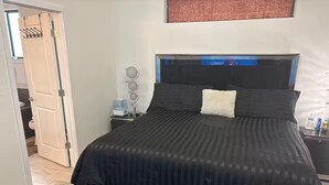 Una camera da letto con un letto grande, un comodino e una lampada a muro.