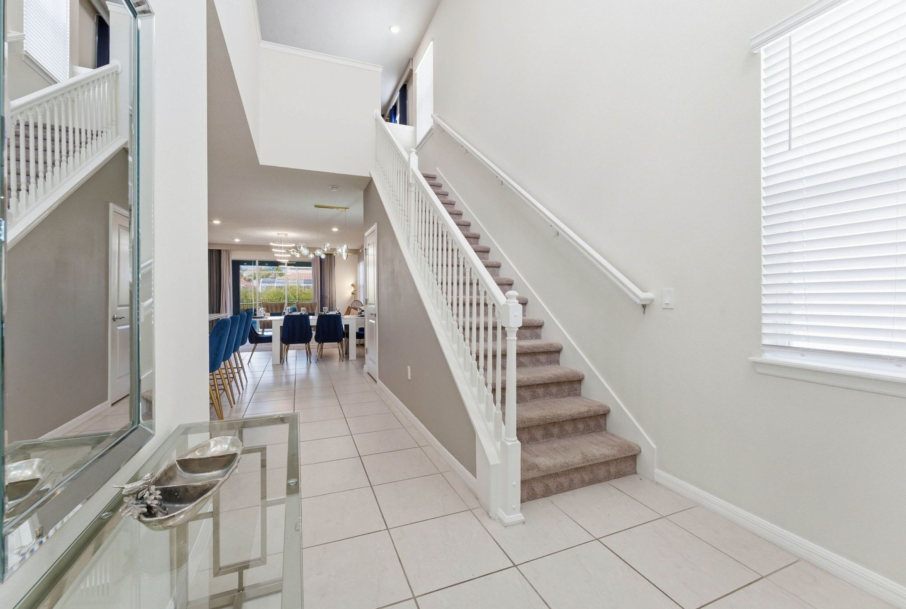 A modern interior with a staircase, a dining area, and a kitchen.