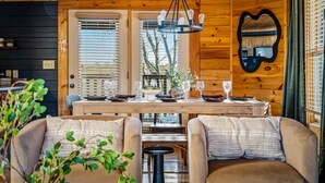 Ein Holzinterieur mit einem für zwei Personen gedecktem Esstisch, einer Chandelierleuchtre und einem herzförmigen Spiegel.