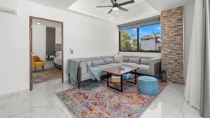 A modern living room with a sectional sofa, a coffee table, and a patterned rug. - Affordable Bucerias 2 Bed. Well Stocked. Walk to Beach. Perfect Pool and Views (Bucerías)