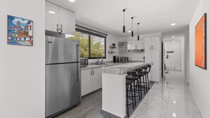 A modern kitchen with a large island, stainless steel appliances, and pendant lighting. - Affordable Bucerias 2 Bed. Well Stocked. Walk to Beach. Perfect Pool and Views (Bucerías)