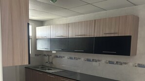 Una cocina moderna con armarios de madera, encimera negra y salpicadero de azulejos.