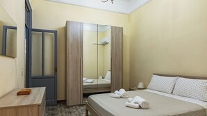 Ein Hotelzimmer mit Bett, Schreibtisch, Kleiderschrank und Spiegel.