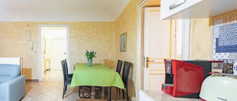 A compact living space with a dining area, a kitchenette, and a sofa.