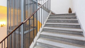 Una scala con ringhiere in metallo e un parapetto a rete su un lato.