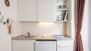 Een kleine keuken met een vaatwasser, een spoelbak en een aanrecht.