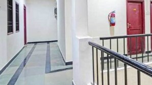 Un couloir doté d’un plancher en verre, de murs blancs et de portes rouges.