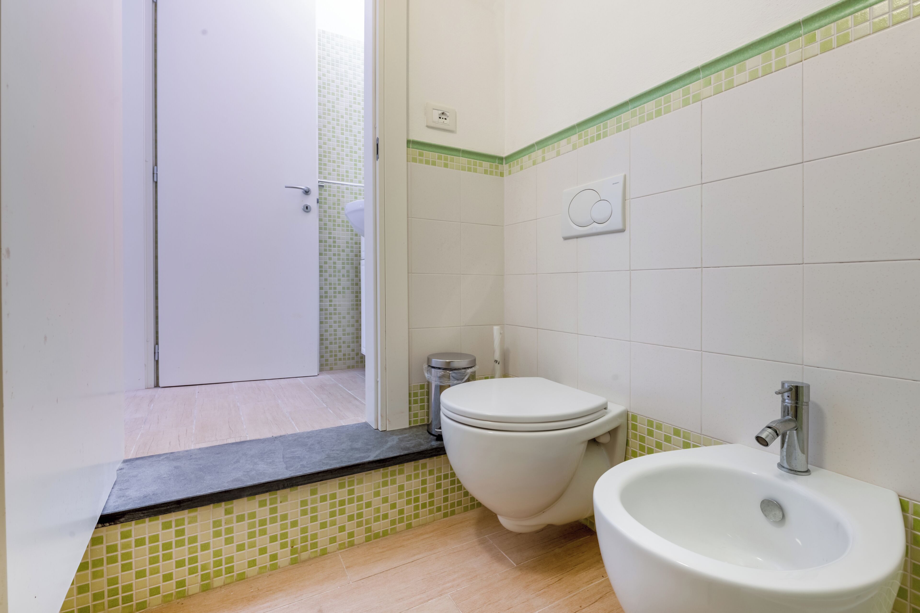 A bathroom with a toilet, bidet, and sink.