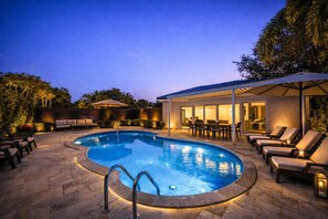 A swimming pool with a sunken center, surrounded by lounge chairs and a covered patio area. - The Rose By Brickell (Miami)