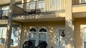 Un bâtiment à deux étages doté d’un balcon, d’une porte ornée d’une ancre et d’une petite table avec des chaises à l’extérieur.