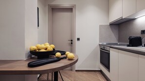 Una cocina moderna con una mesa de madera, un bol de limones y una cafetera.