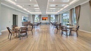 A spacious conference room with a long table and chairs, large windows, and a painting on the wall. - CT 7344 Pond and Fountain View Condo - Welcome to Paradise (Fort Pierce)