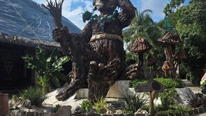 A large wooden statue in an outdoor setting with a thatched-roof structure nearby. - Eco Resort with 1-bedroom hotel suite in charming Playa del Carmen with AC (Playa del Carmen)