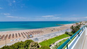 A beach with umbrellas and lounge chairs, a promenade, and a view of the sea. - Carteia Beachfront at Praia da Gaivota (Loulé)
