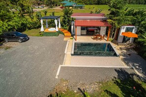 A modern house with a swimming pool, a covered patio, and a car parked in the driveway. - Magic Villa with private pool & jacuzzi (La Fortuna)