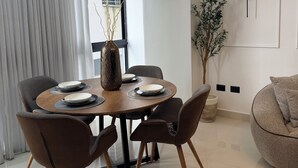 Un comedor moderno con una mesa redonda, seis sillas y un jarrón decorativo.