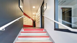 A staircase with red and white steps, white handrails, and a tiled wall. - 30 - Le Lokup - Wifi - Proche tram (Reims)