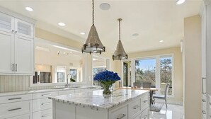 A modern kitchen with a large island, white cabinetry, and pendant lighting. - Luxury Mansion available with Pool, Gym and More - Perfect for entertaining (Atlanta)