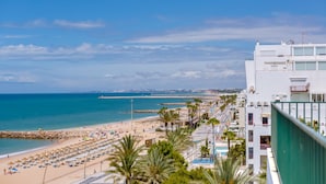 A beachside hotel with a view of the ocean and a rocky breakwater in the distance. - Carteia Beachfront at Praia da Gaivota (Loulé)