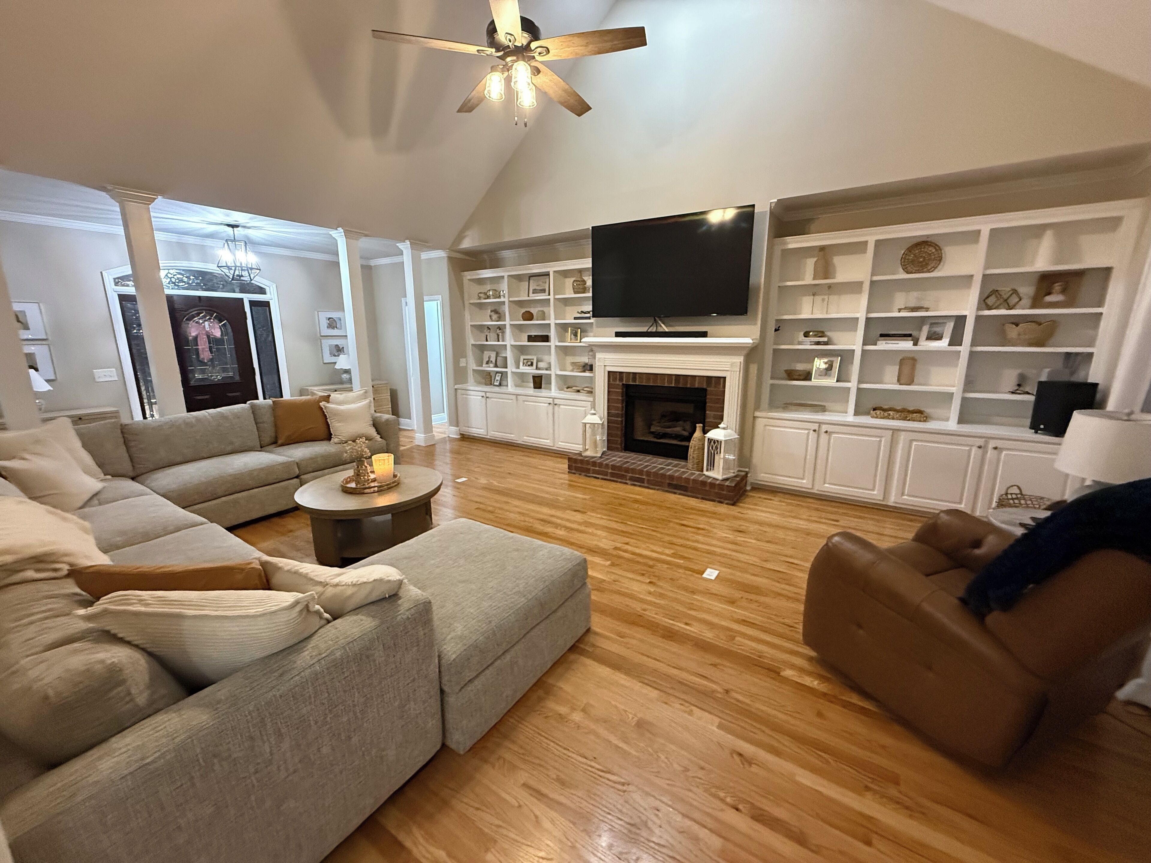 A living room with a fireplace, a television, and built-in shelving.