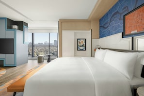 A hotel room with a large bed, a television, a desk, and a view of the city. - Le Méridien Changzhou (Changzhou)